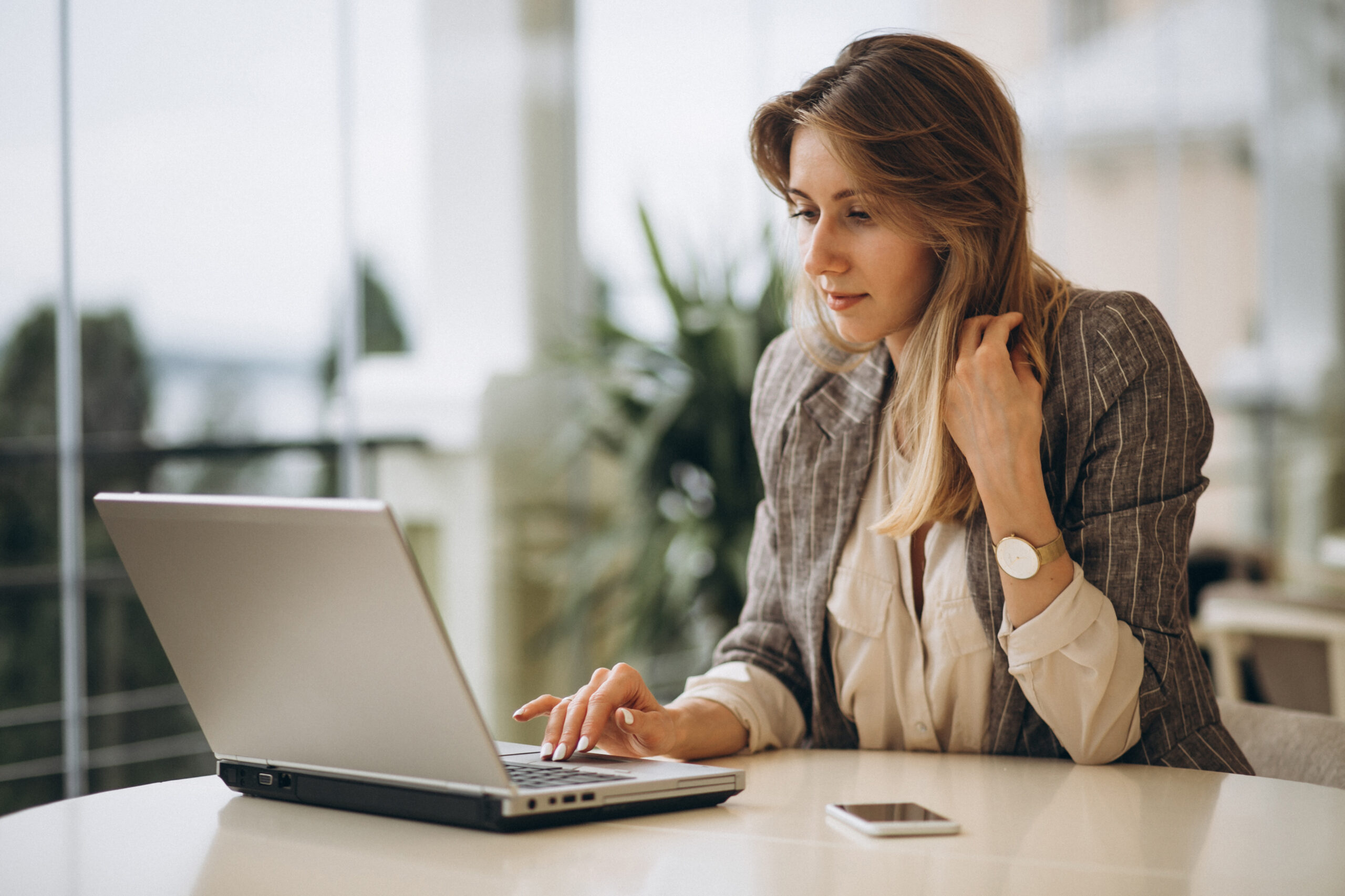 Perché conoscere gli ATS è importante per trovare un lavoro? L'immagine ritrae una giovane donna al computer che cerca un lavoro.